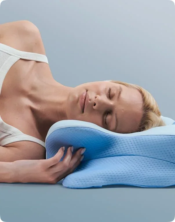 Woman sleeping on her side with her head resting on a blue Derila Ergo pillow